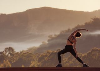 Woman enjoying morning yoga with valley views at Emirates One&Only Wolgan Valley