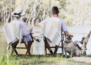 Couple and their dog enjoying an afternoon of fishing on the banks of the Murrumbidgee River, Hay