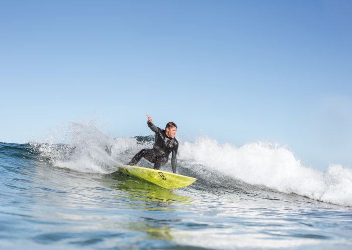 Surfer catching a wave off Werri Beach, south of Kiama on the South Coast