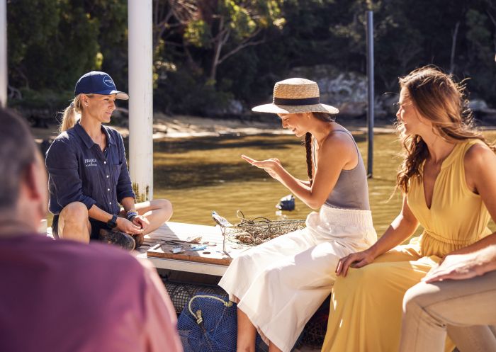 Guest examining a freshly farmed pearl on a tour of the Broken Bay Pearl Farm, Mooney Mooney