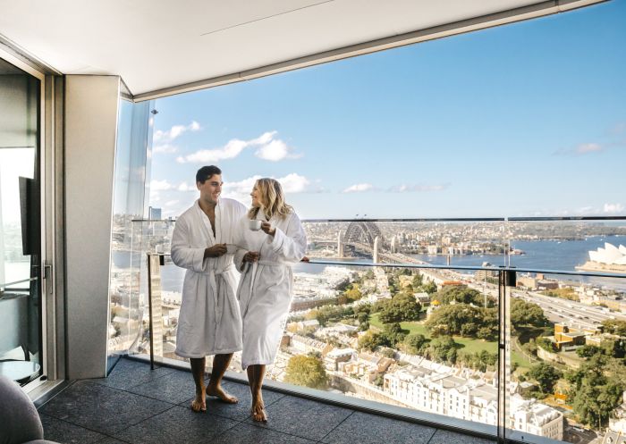 Couple enjoying a coffee and harbour views from their luxurious Crown Towers hotel suite at Crown Sydney, Barangaroo