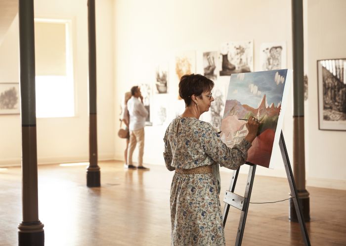 Artist Amanda Johnson painting at Broken Hill City Art Gallery, Broken Hill