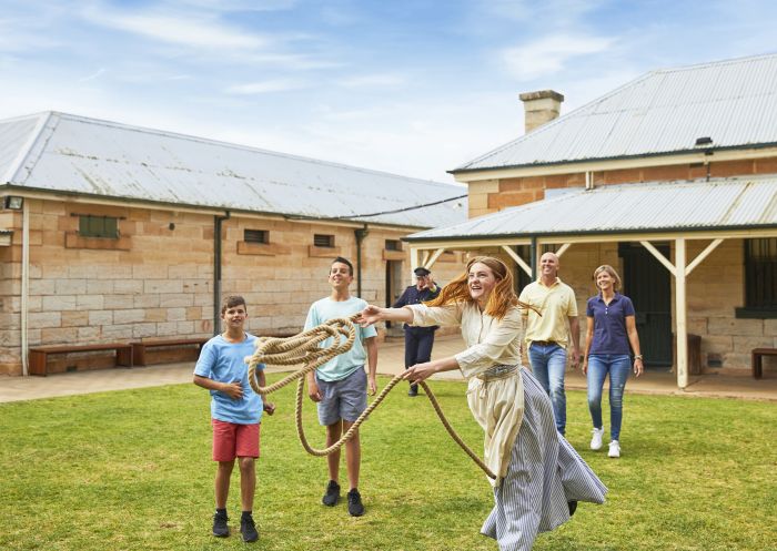 Family enjoying an guided tour with a prison warden and prisoner at the Old Dubbo Gaol