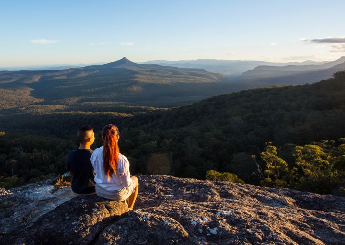 Couple enjoying panoramic views across to Pigeon House Mountain (Aboriginal: Didthul) in Morton National Park,  Jervis Bay & Shoalhaven, South Coast