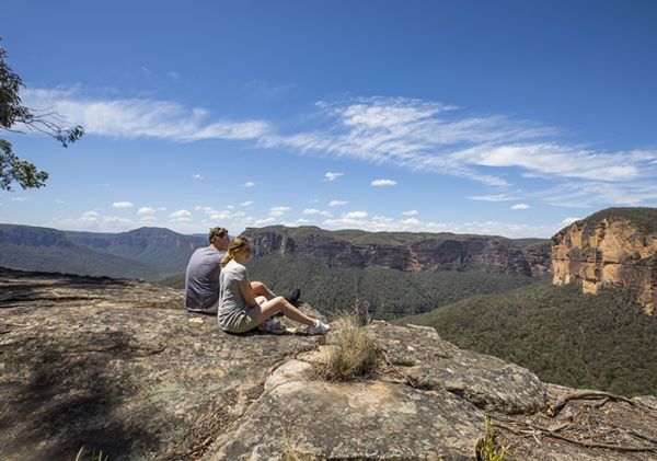 Couple enjoying views of the Grose Valley, Blackheath along the Grand Canyon Walking Track in the Blue Mountains