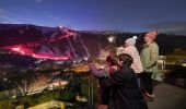 Family watching skiiers and snowboarders participating in the Saturday night flare run tradition at Thredbo in the Snowy Mountains