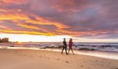 Couple enjoying a morning walk along the beach near Camel Rock, Bermagui