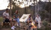 Family enjoying a campfire by their tent on the Hawkesbury River in Lower MacDonald