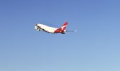 Qantas plane taking off from Sydney airport, with views to the city in the background