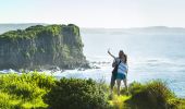 Couple taking photos on the scenic Minnamurra Headland overlooking Rangoon Island, Kiama Coast Walk in Kiama, South Coast