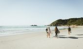 Surfers walking along Broken Head Beach, Byron Bay