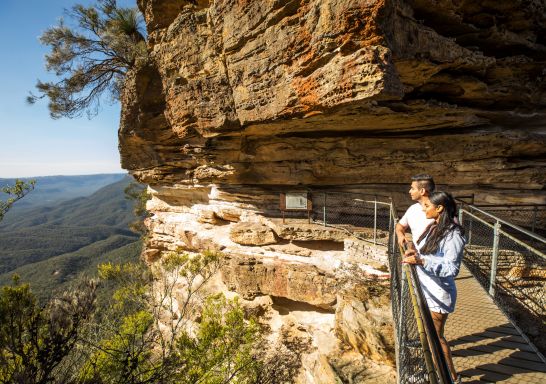 Couple enjoying views from Honeymoon Bridge overlooking the Jamison Valley along the Three Sisters Walking Trail, Katoomba